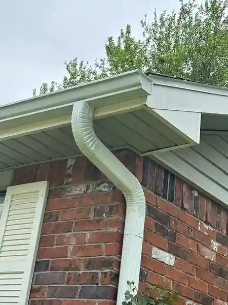 New downspout attached to gutters directing water away from the foundation of an Arlington, VA home