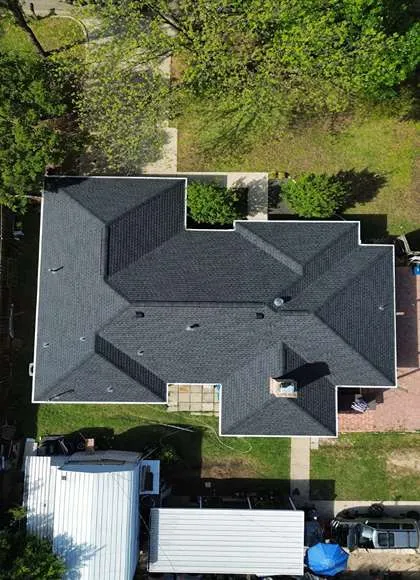 Happy Arlington Virginia homeowners standing in front of their home with a freshly completed new roof installed by local roofing company