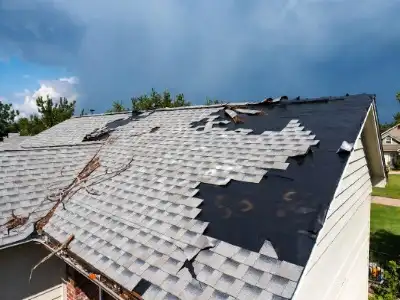 Storm damage roof repair in Arlington, Virginia hail and wind damaged shingles being inspected and restored by local roofer